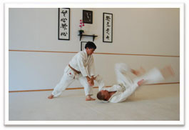 Senpai Gary Okuma executing Aikido technique on another adult student