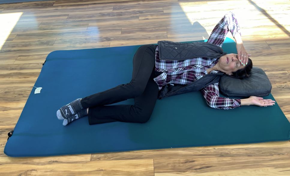 a student lying on her side during a Feldenkrais class