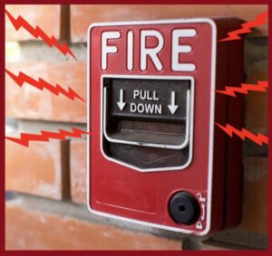a fire alarm switch on a brick wall
