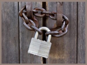 A padlock and chain securing two door handles togehter