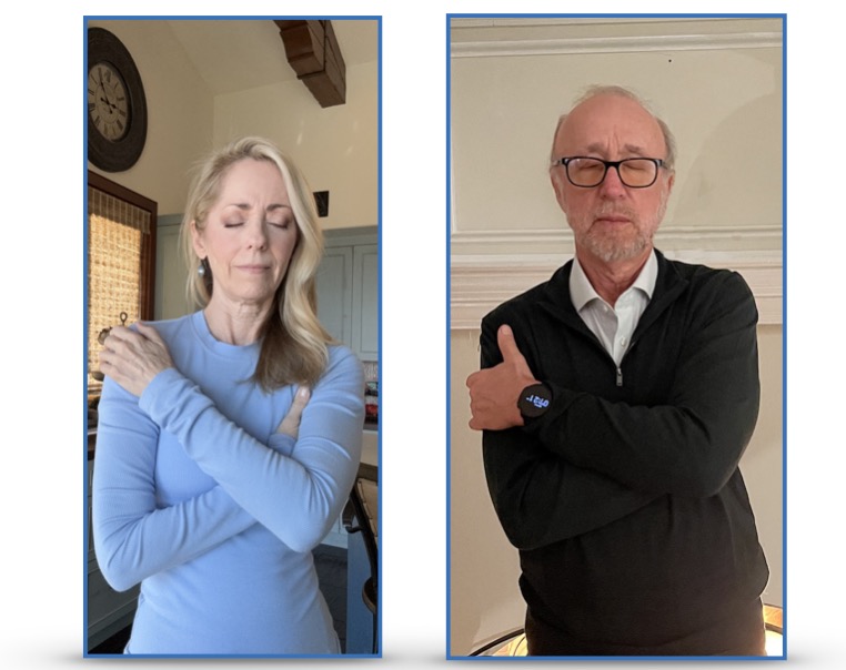 A woman and a man demonstrate hugging themselves