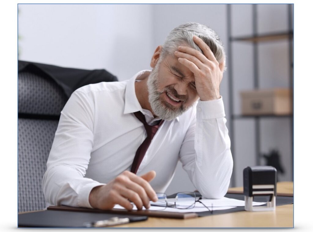 A man holds his head while looking stressed